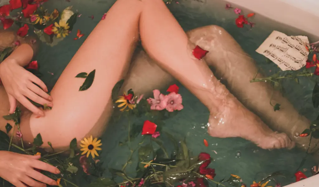 The lower body part / legs of a female in a bath.